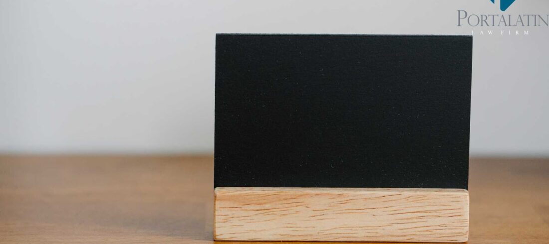 A small blank chalkboard with a wooden base sits on a table, indicating the endless possibilities of what your business name can be.