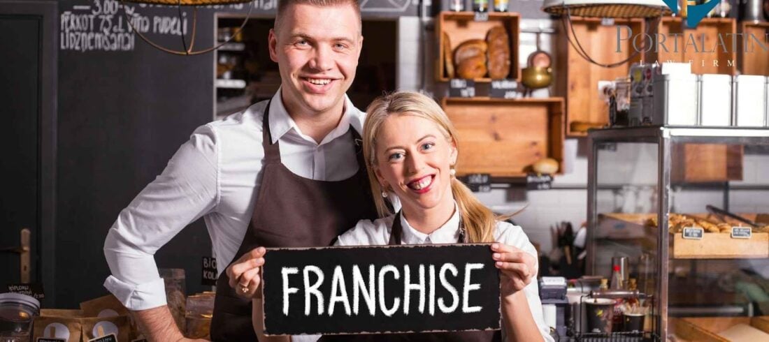 Smiling cafe owners holding franchise sign.