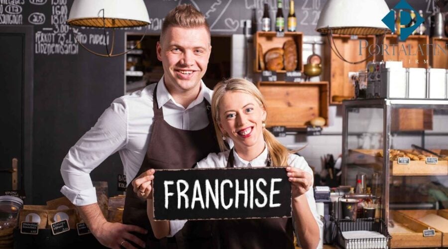 Smiling cafe owners holding franchise sign.