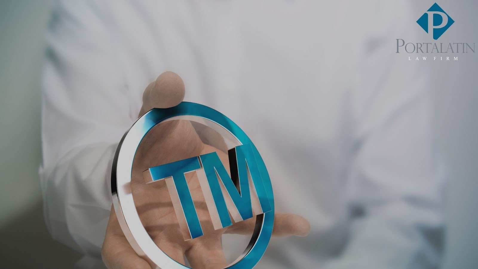 Person holding TM symbol, Portalatin Law Firm logo