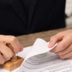 Lawyer stamping legal document at desk.