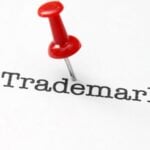 Trademark with red pushpin on paper