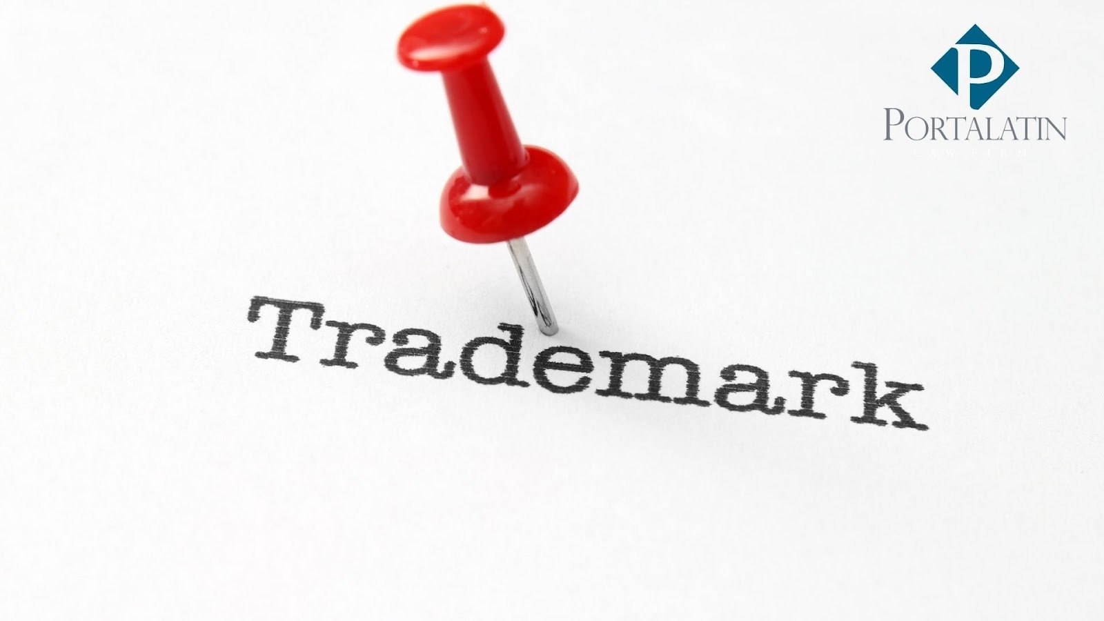 Trademark with red pushpin on paper