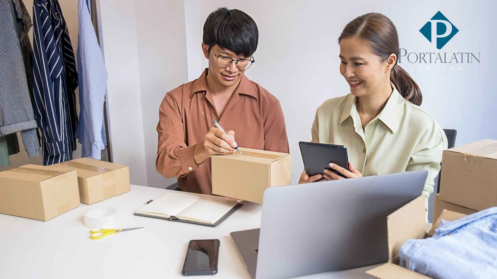 Two people packaging boxes with tablet and laptop.